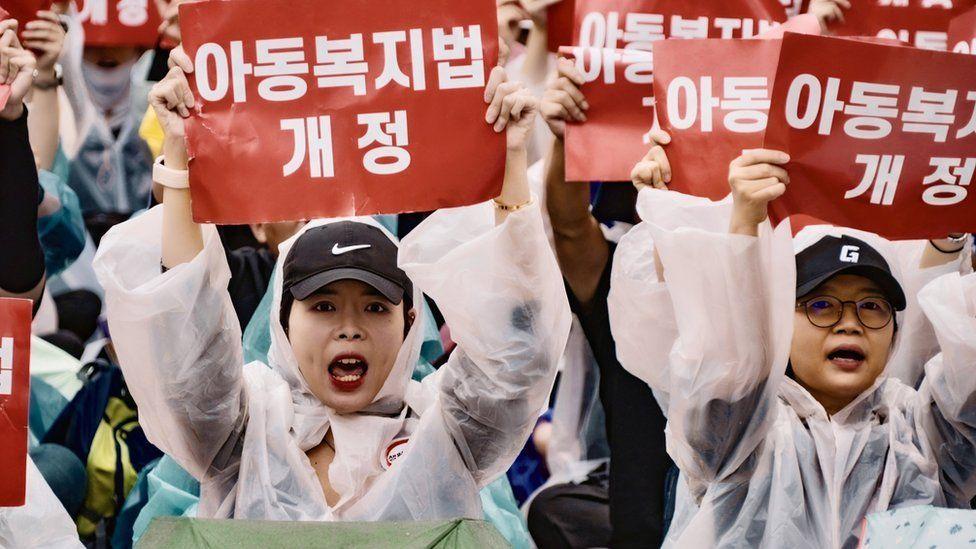 Dos profesoras sostiene carteles durante las protestas de maestros en Corea del Sur