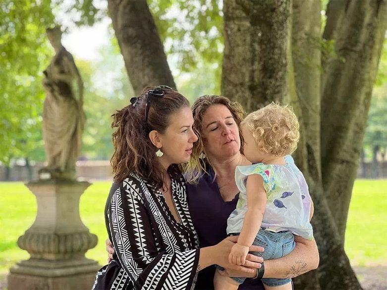 Dos mujeres acarician un bebe