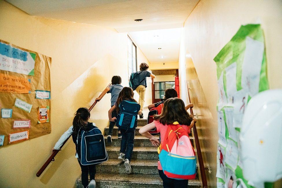 Niños corriendo por una escuela