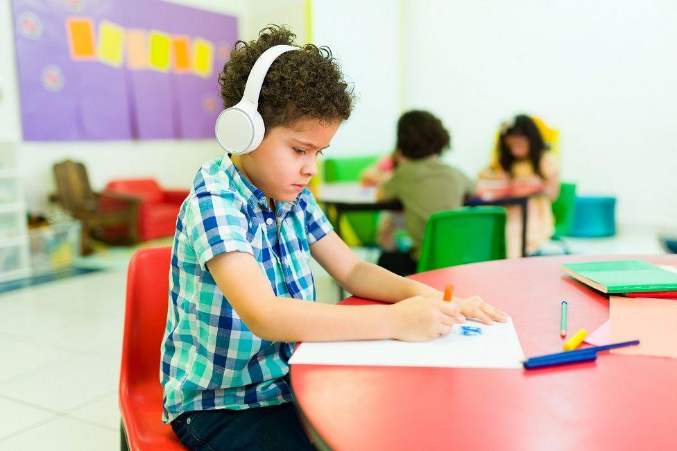 Niños con audífonos coloreando