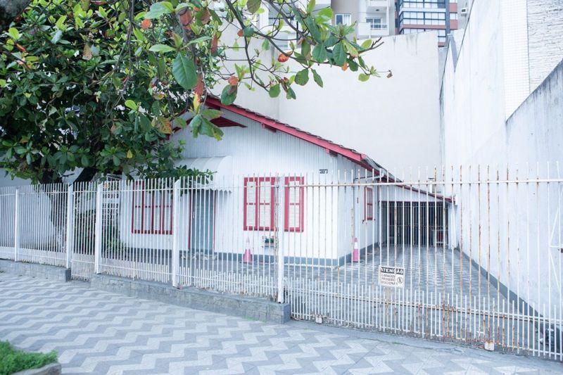 Una casa blanca con ventanas rojas y techo rojo que será demolidad 