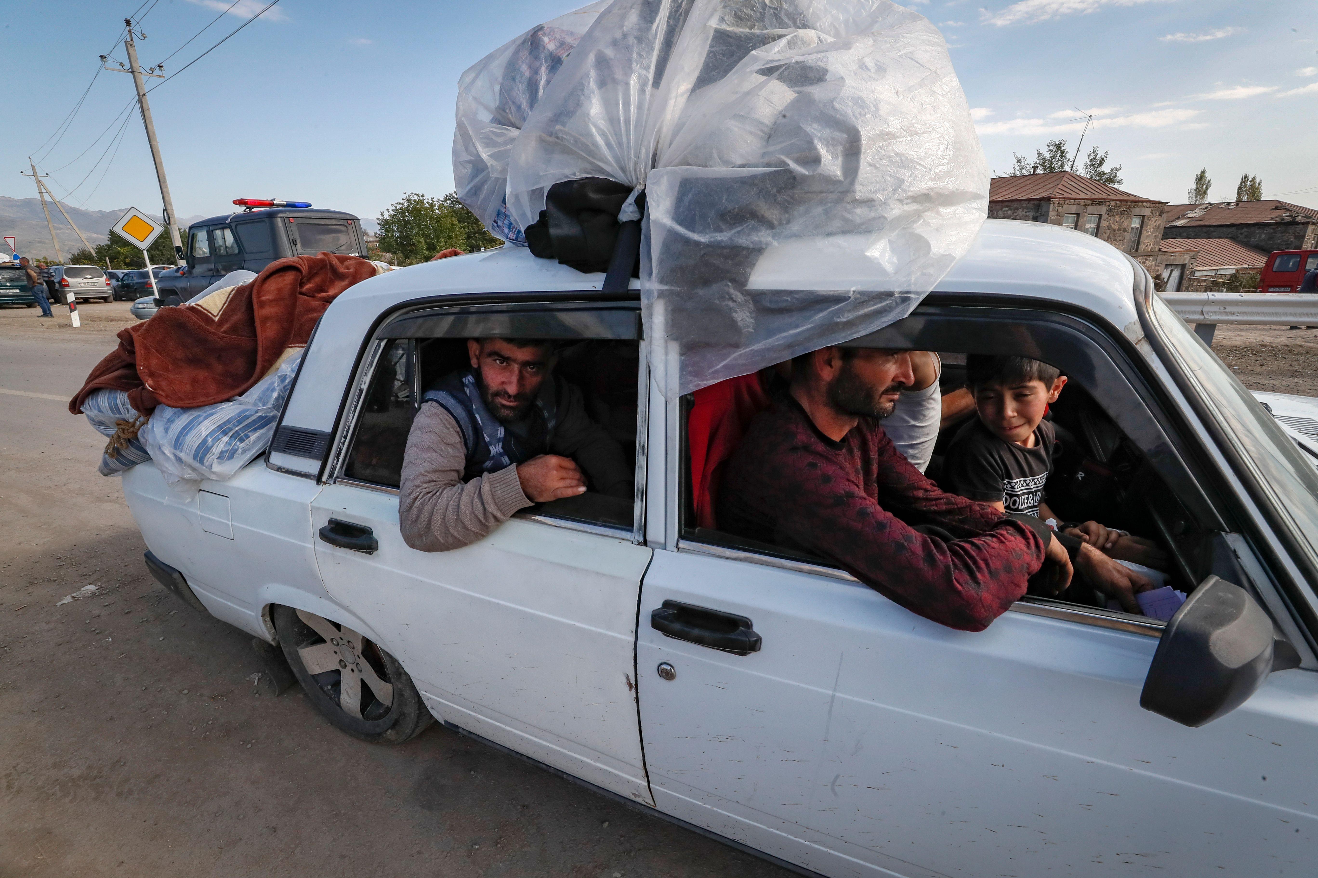 Hombres y niños en un auto repleto huyen desde Nagorno Karabaj a Armenia.