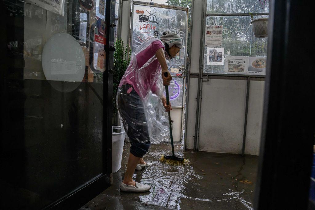 Las personas intentan deshacerse del agua que ingresa a sus negocios