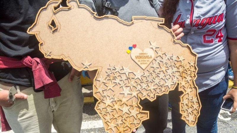 Venezolanos con el mapa de Venezuela. 