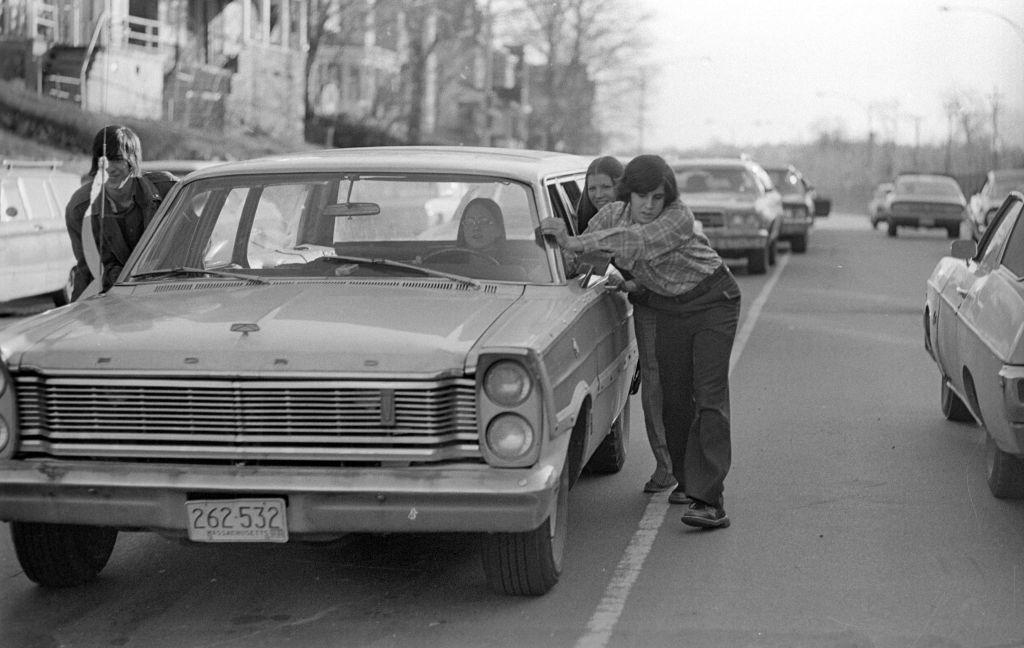 Estadounidenses empujan un auto sin gasolina en una imagen de archivo.