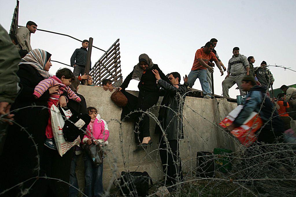 Personas cruzan un muro.