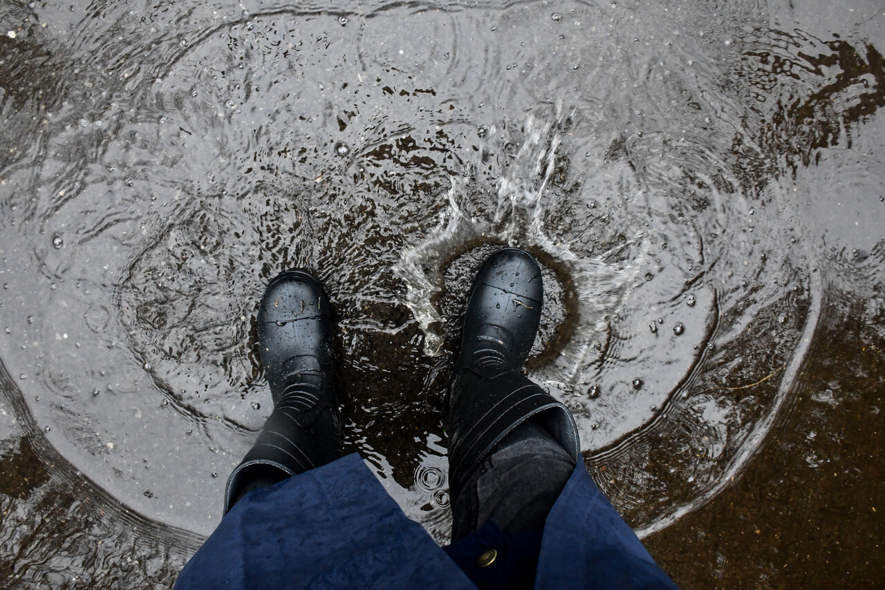 Botas en charco de agua. Lluvia en Santiago