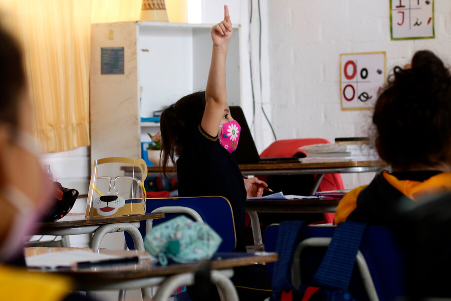 Estudiante levantando la mano en clases. Día del Profesor.