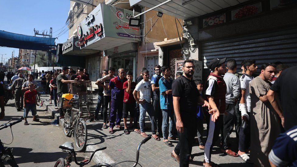 Los palestinos esperan para comprar pan después de que Israel restringiera el área de servicios básicos como agua, electricidad y alimentos en Khan Younis.