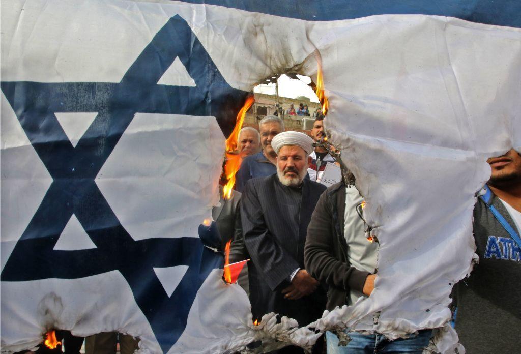 Manifestantes queman una bandera israelí durante una manifestación organizada por Hezbolá en las calles de la ciudad de Sidón, en el sur de Líbano.