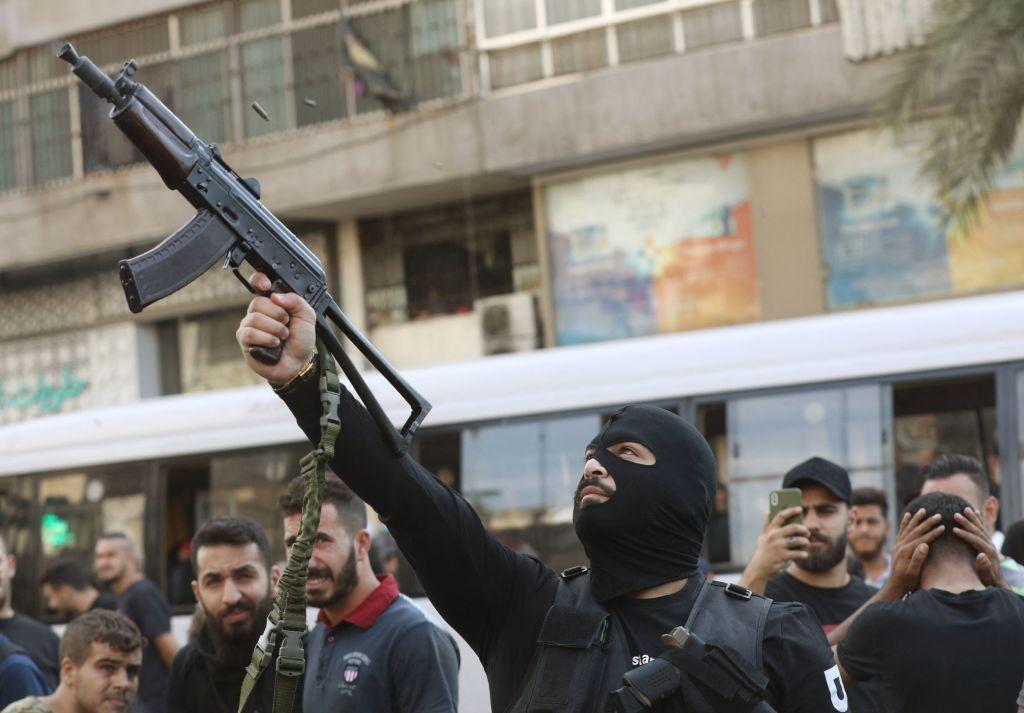 Un miembro del movimiento libanés Hezbollah disparando durante el funeral de uno de sus miembros en 2021.