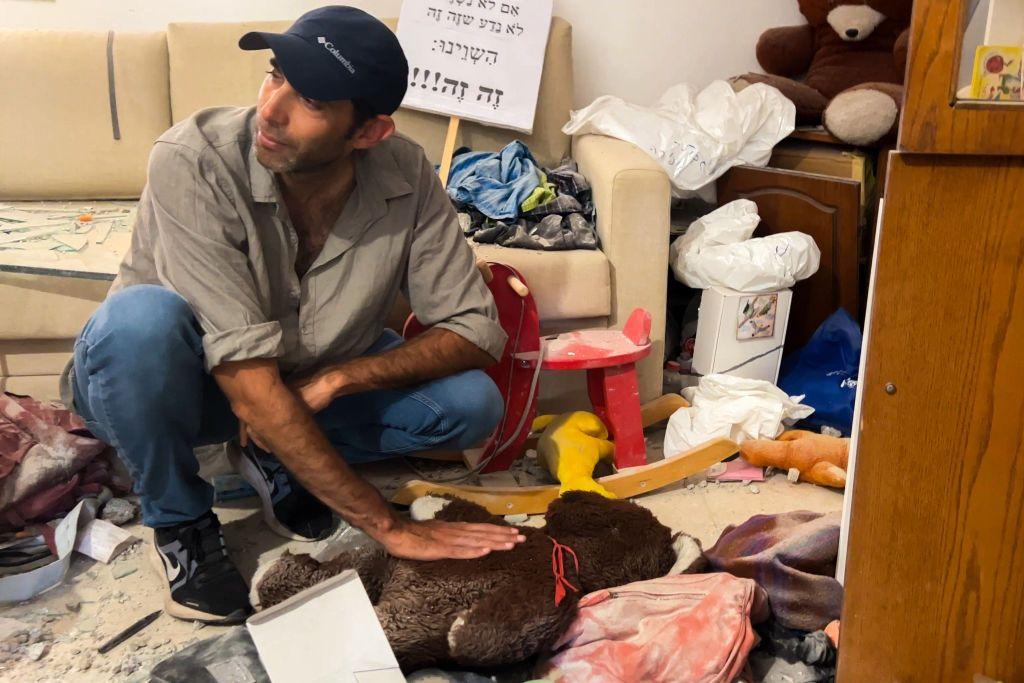 Un hombre toca un oso de peluche.