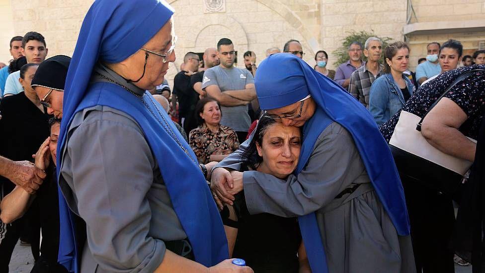 Las mellizas María del Perpetuo Socorro (izq) y María del Pilar Llerena Vargas consuelan familiares de víctimas palestinas