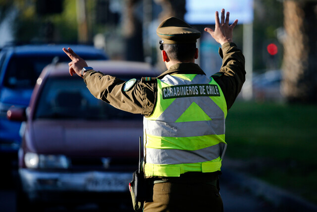 Carabinero deteniendo un vehículo para fiscalizarlo