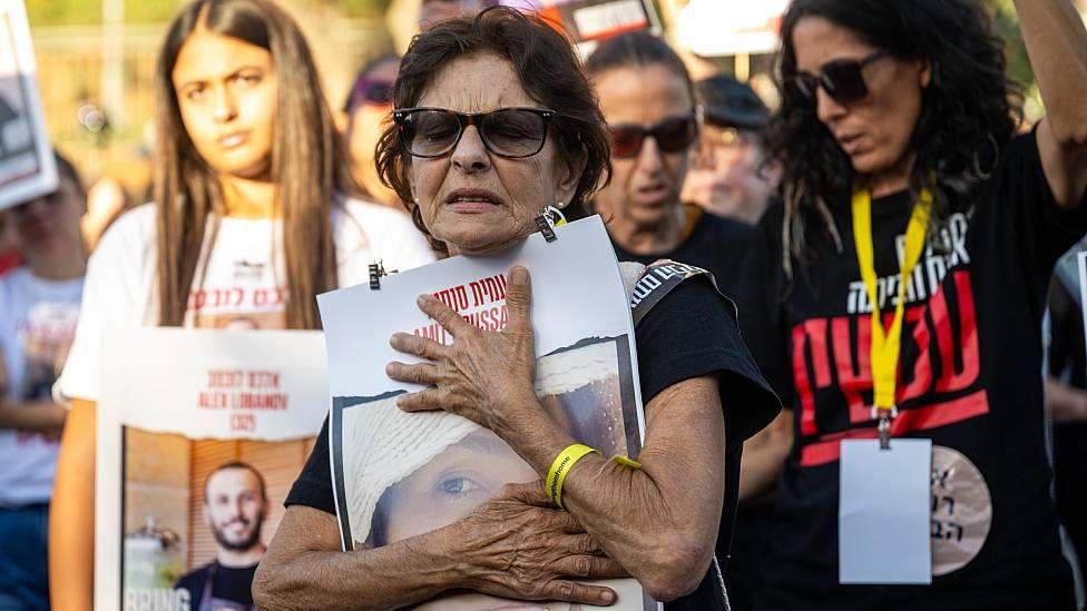 Madre de una joven que tomada rehén por Hamas con una imagen de su hija