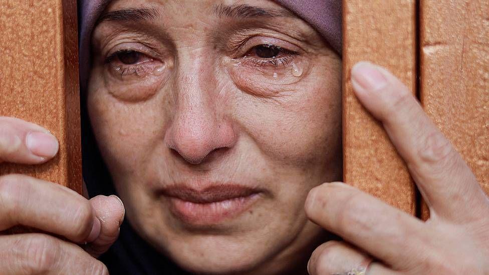 Mujer en Gaza llorando cerca de los restos de víctimas de los bombardeos israelíes
