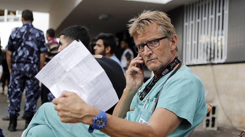 Mads Gilbert sentado hablanco en su celular en el hospital Al Shifa en Gaza en 2014