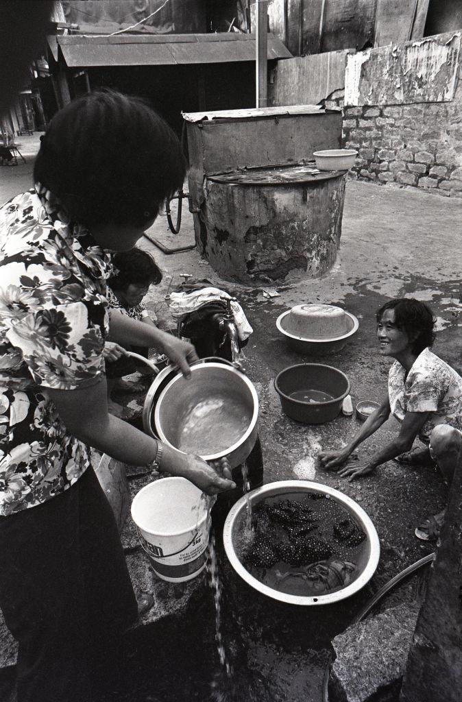 Mujeres limpiando cazuelas en la calle