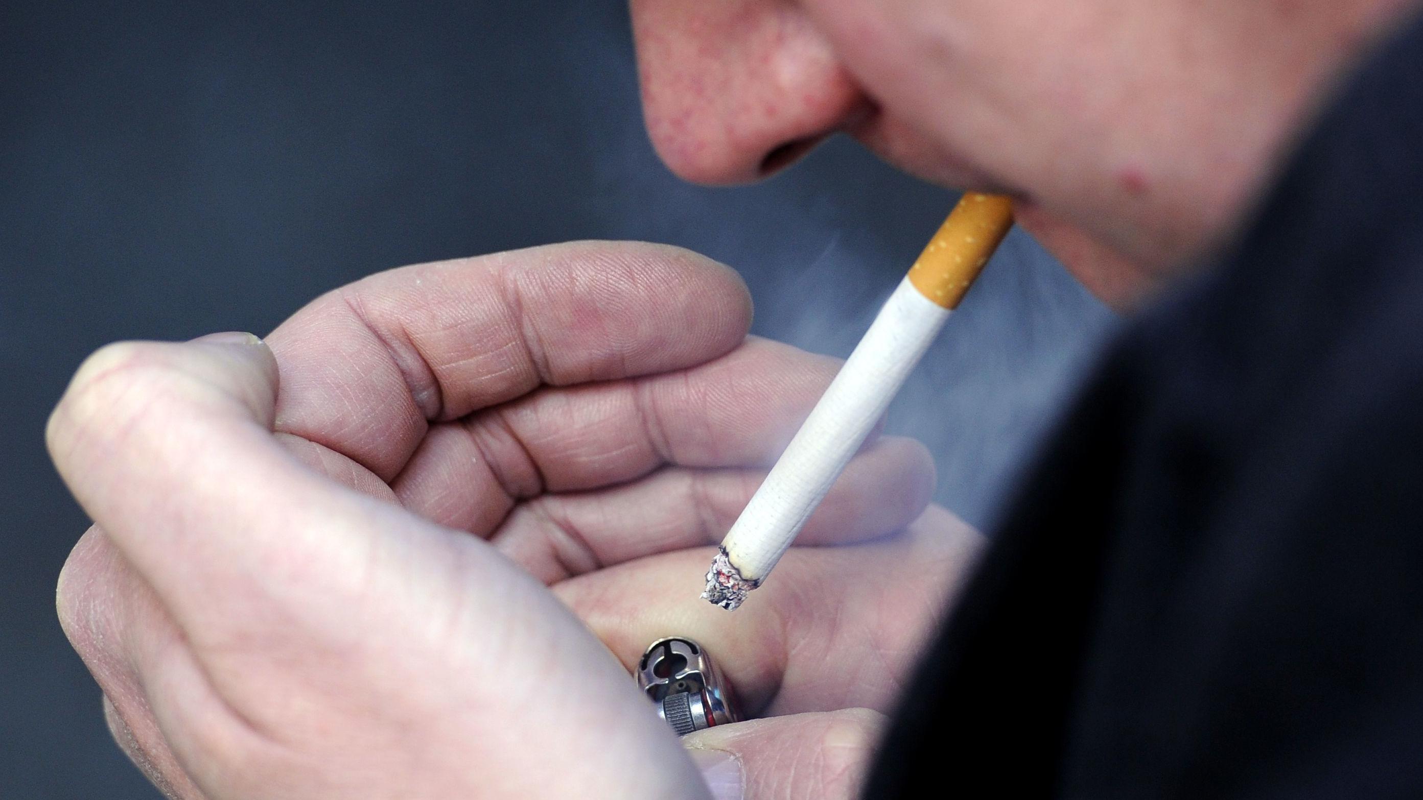 Hombre encendiendo un cigarrillo.