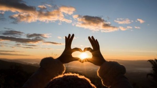 Símbolo de corazón en el atardecer. Frases de amor de buenos días.