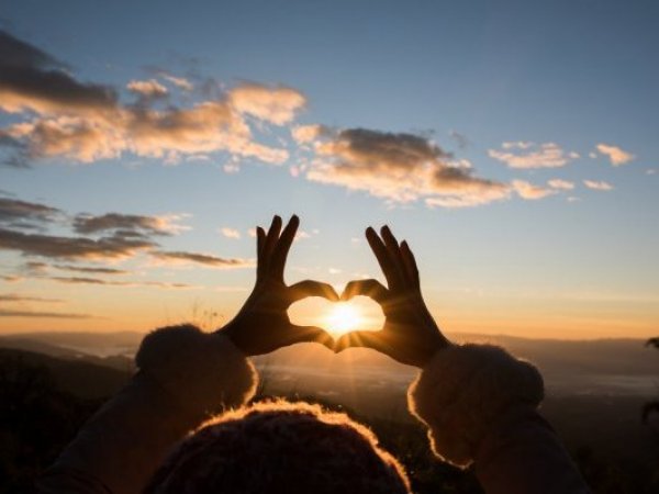 Símbolo de corazón en el atardecer. Frases de amor de buenos días.