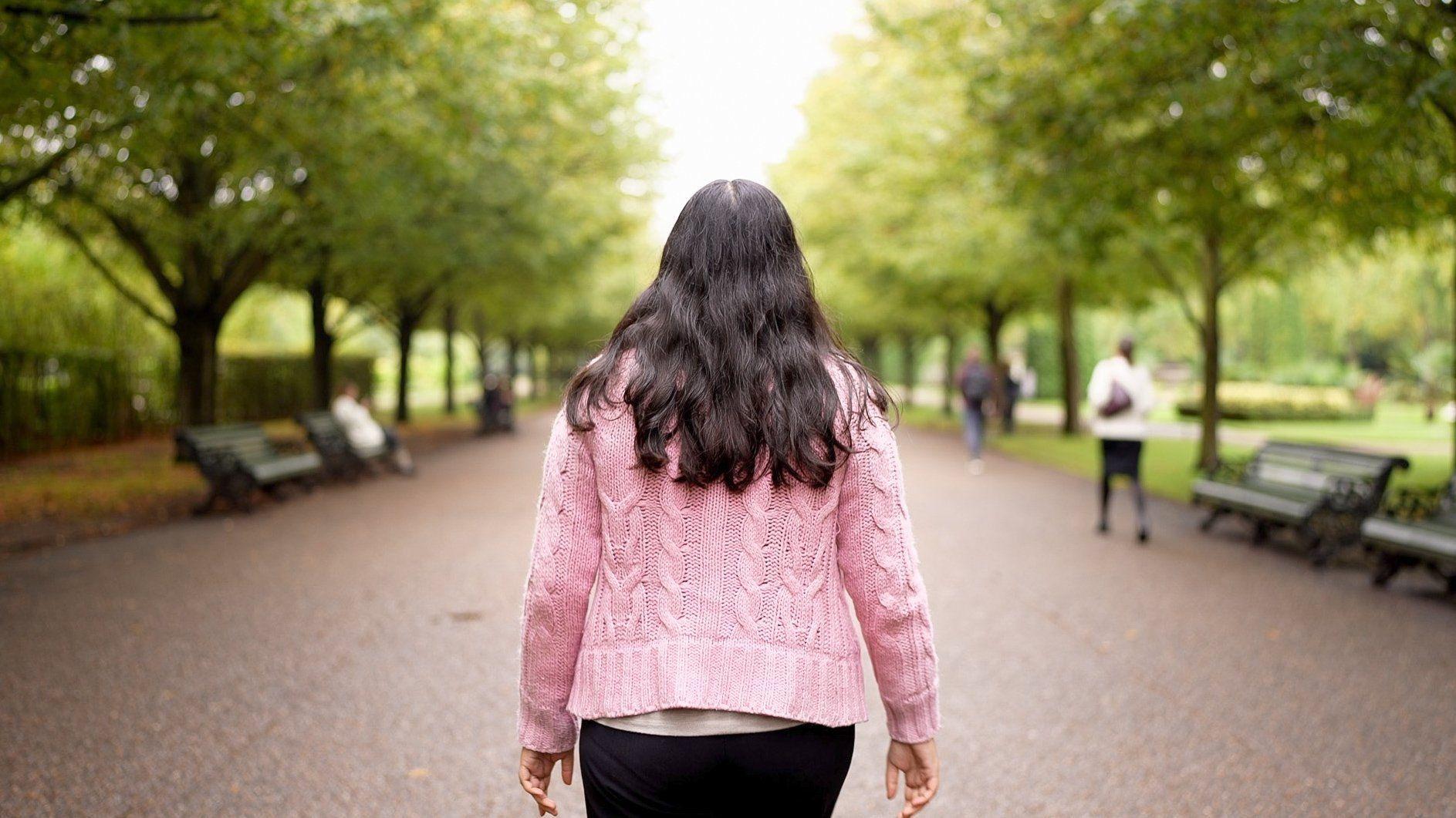 "Lucy" caminando por un parque de Londres de espaldas