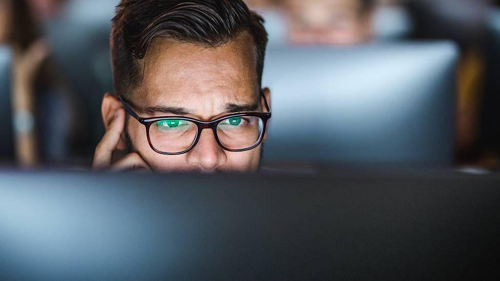 Hombre concentrado frente a su computadora