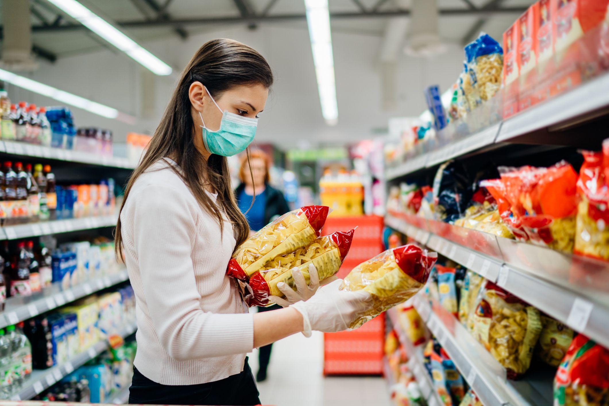 Una mujer con máscara y guantes en el supermercado