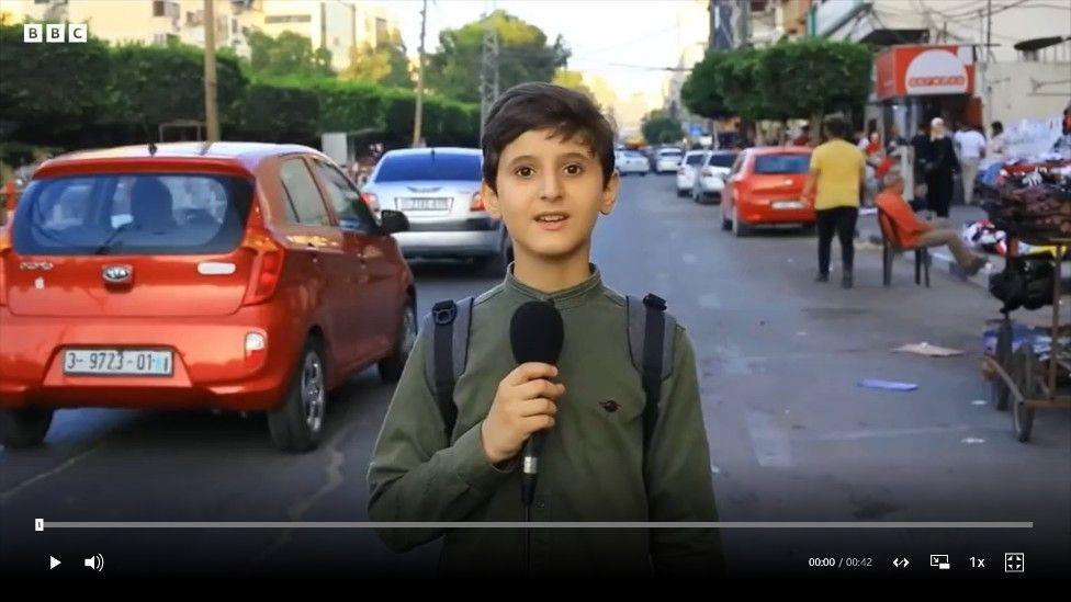 Awni en la calle con un micrófono en la mano