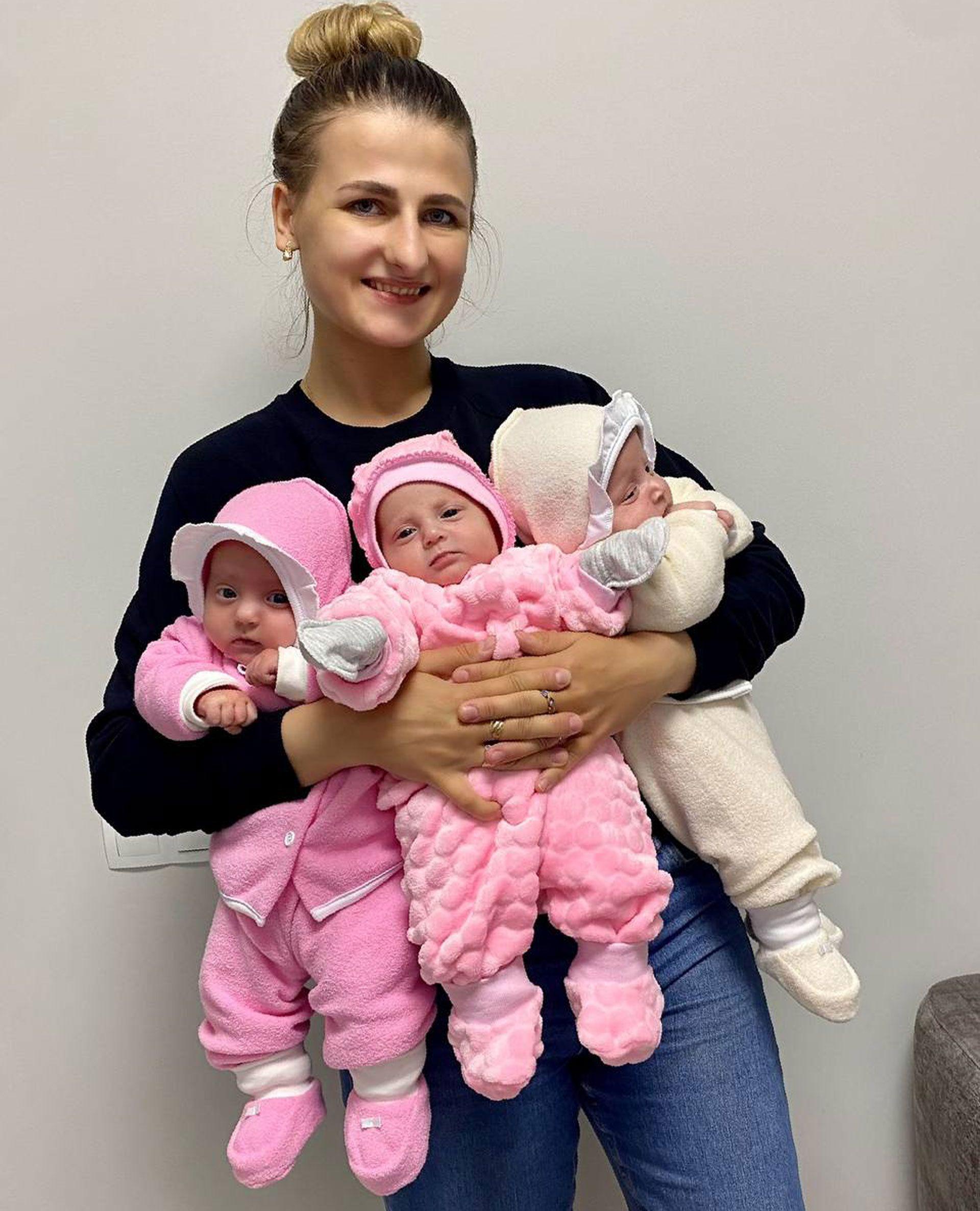 Hanna sosteniendo a sus tres hijas.