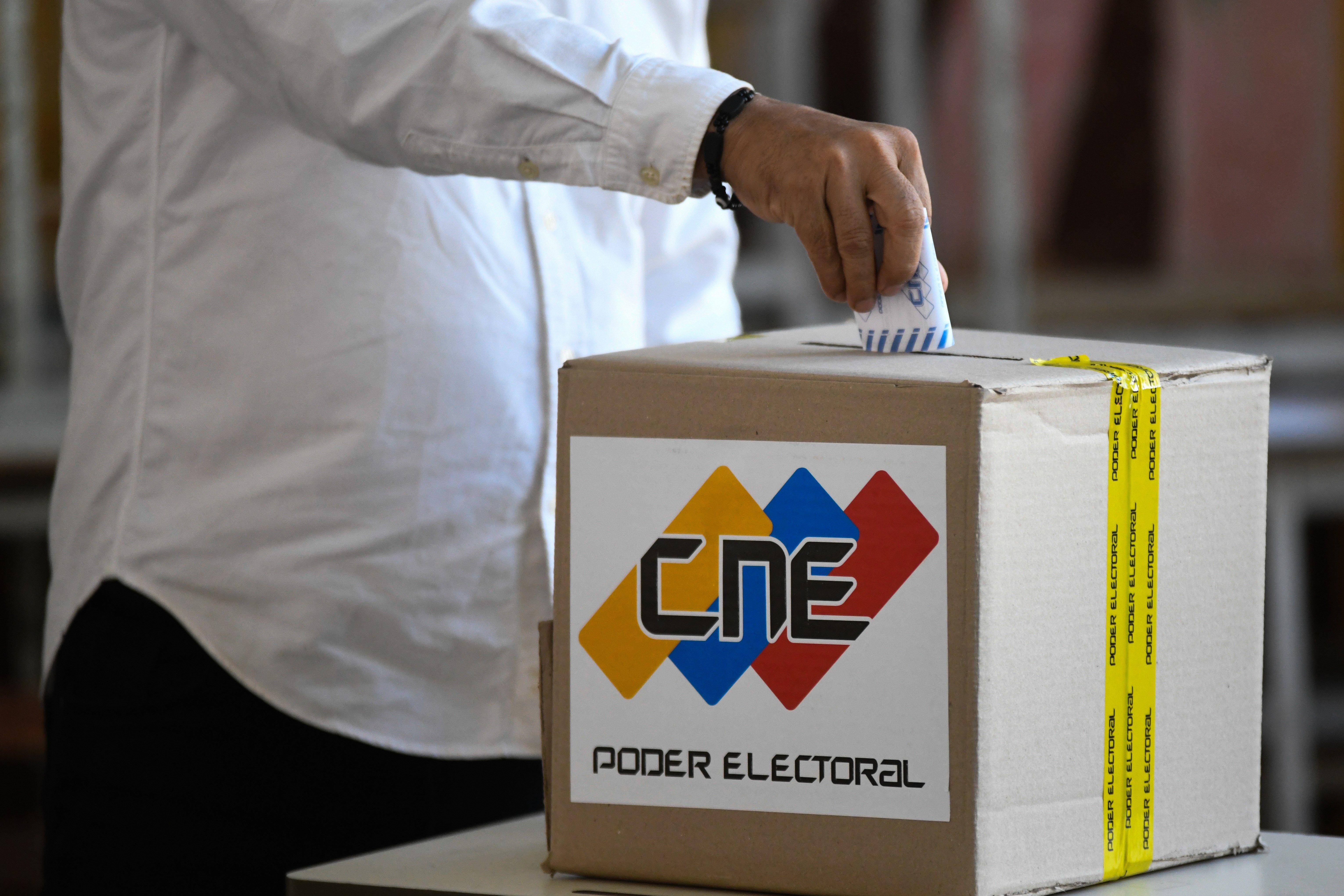 Una persona deposita su voto en una urna en venezuela. 