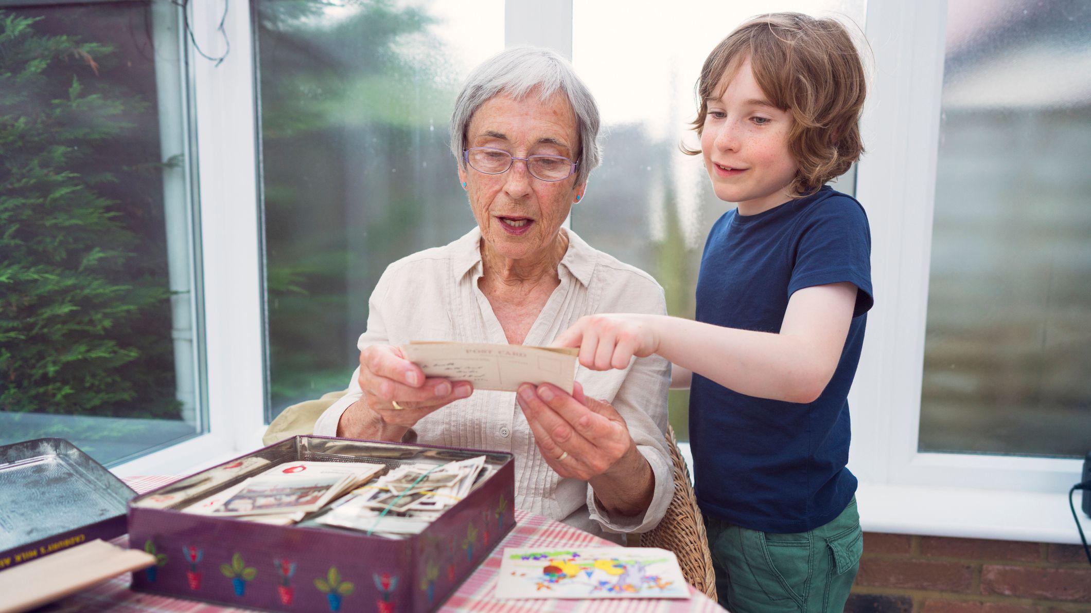 Una anciana con un niño miran fotografías. 