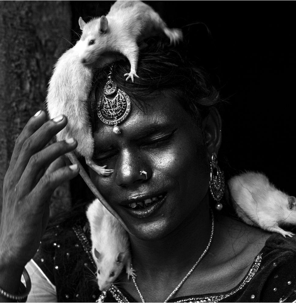 Mujer dalit con una rata en la cabeza.