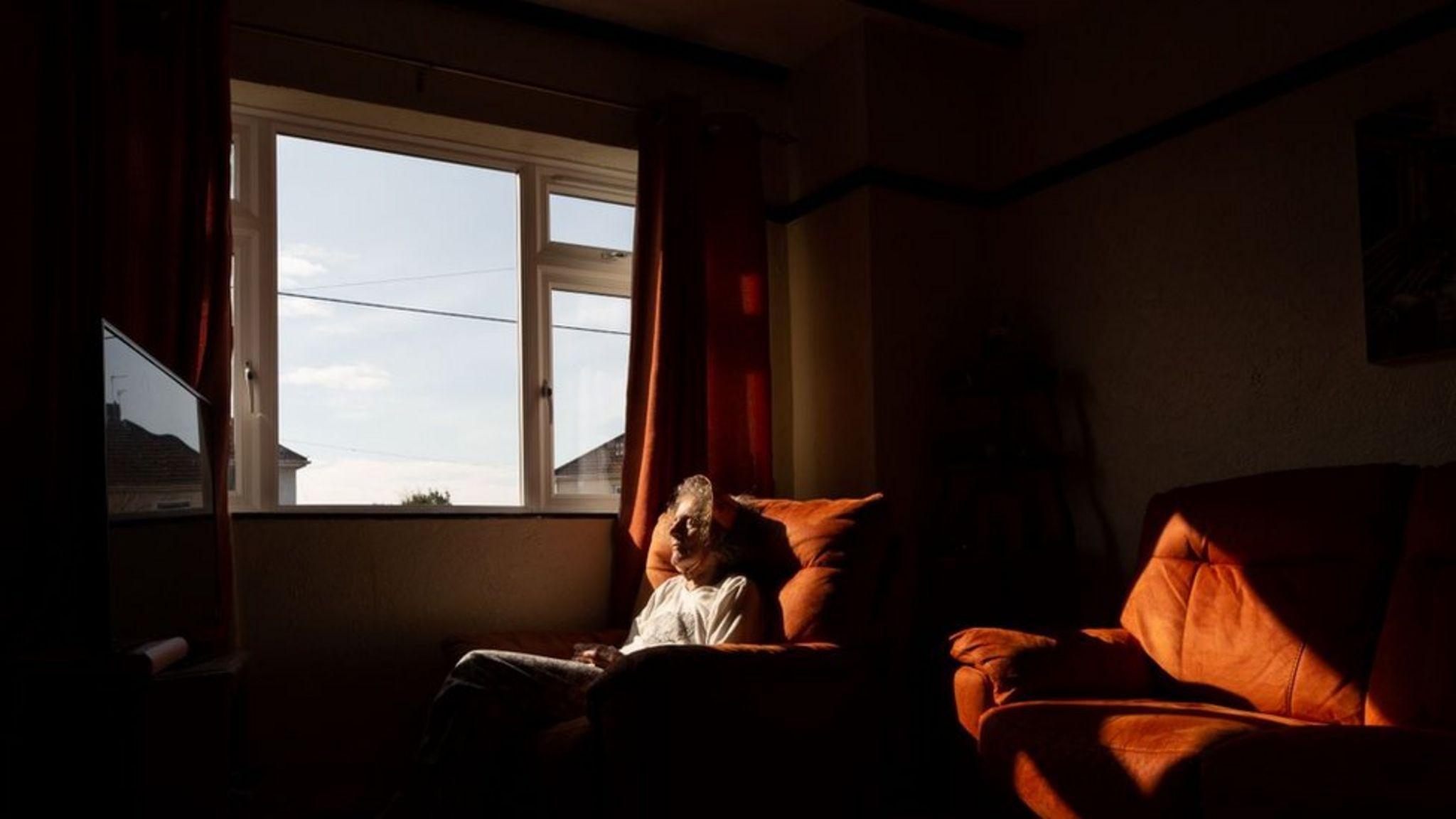 Susan sentada en un sillón junto a la ventana de su casa.