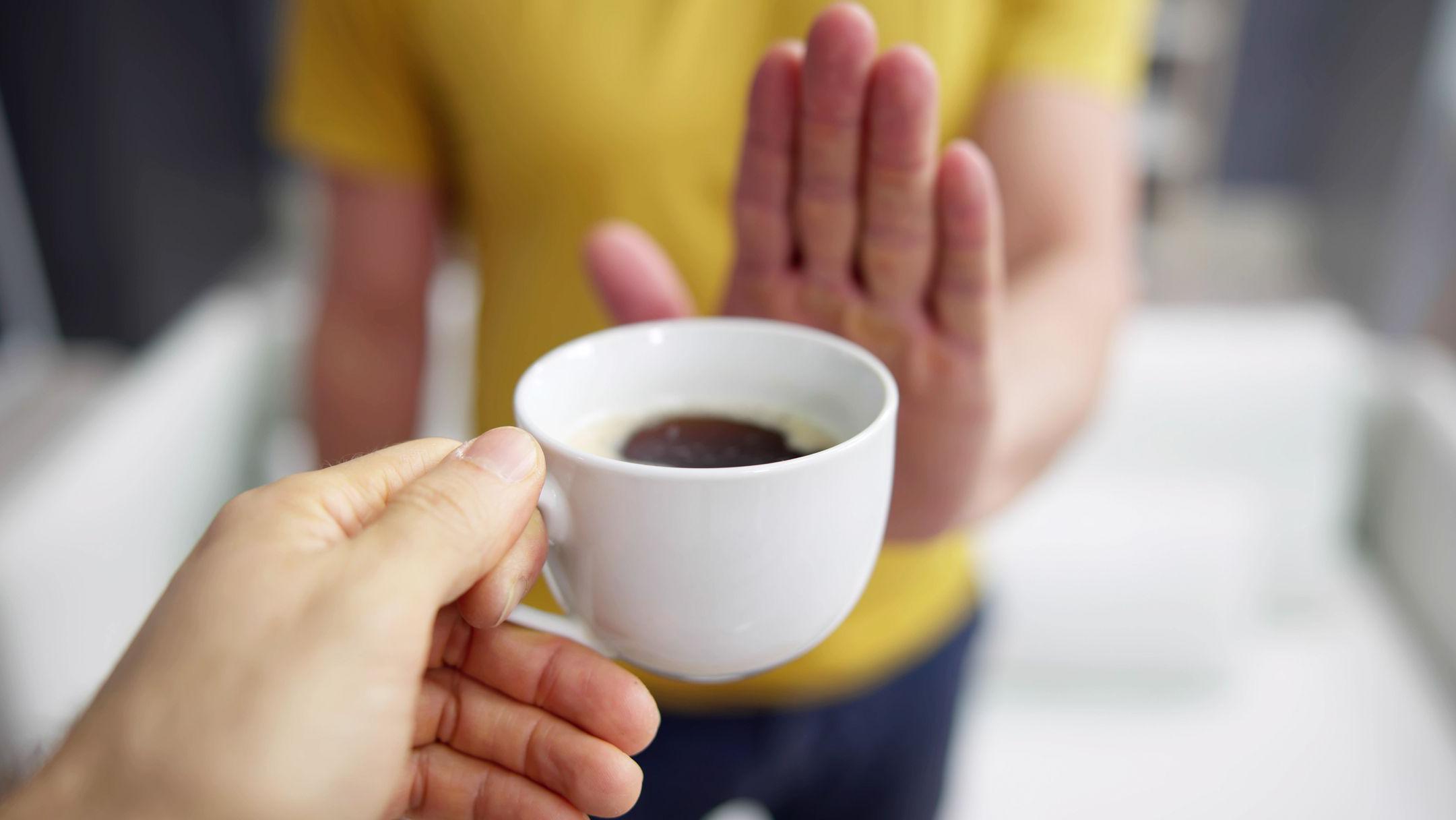 Una persona rechaza la oferta de una taza de café