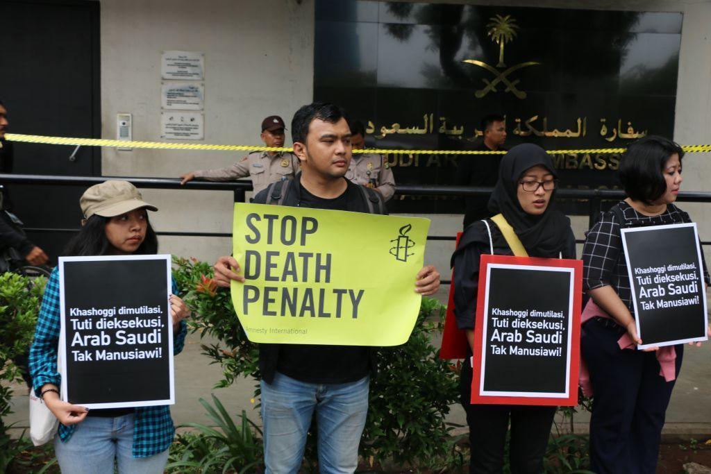 Cuatro persones muestran carteles de protesta en Indonesia contra la pena de muerte en Arabia Saudita. 