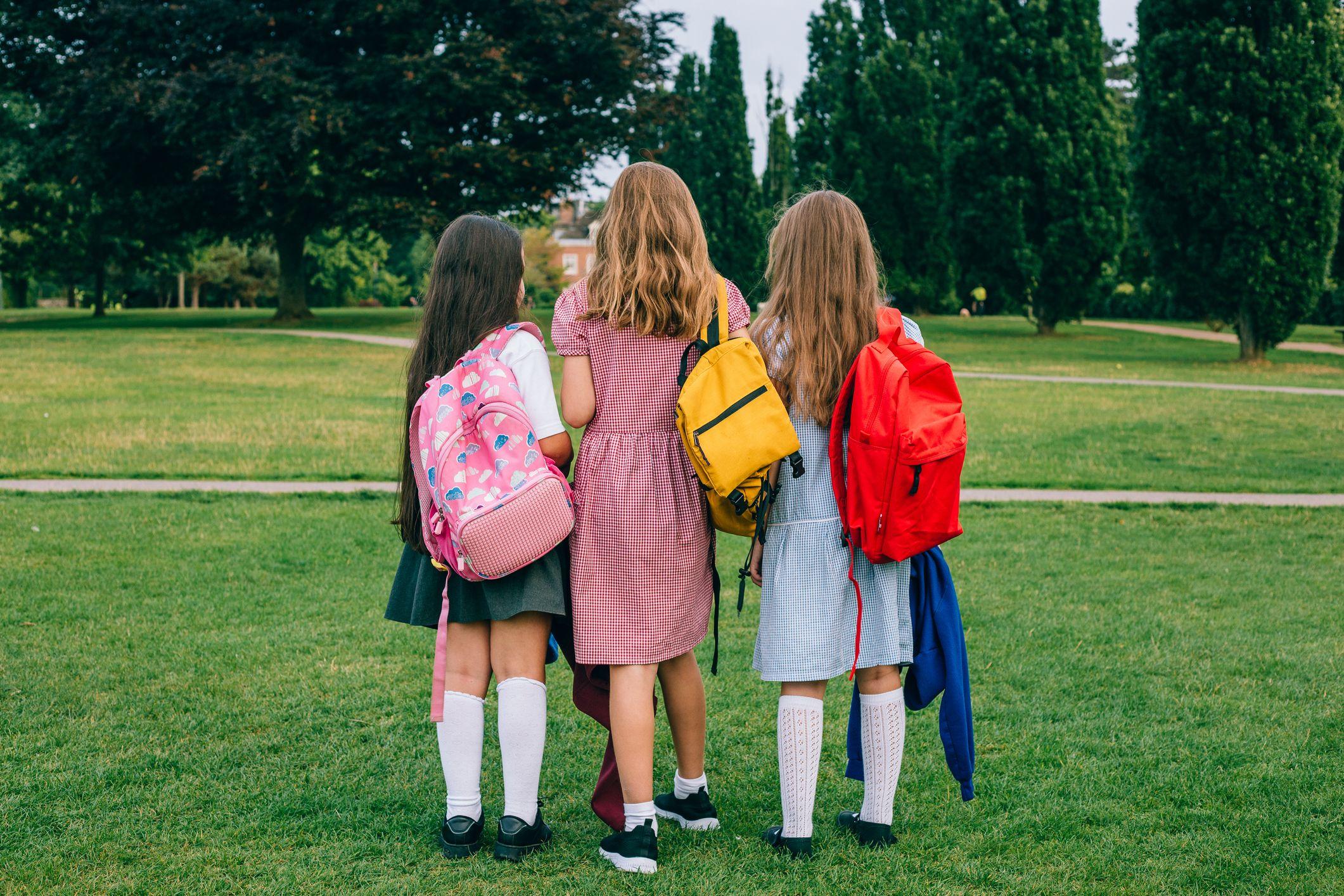 Tres escolares en un parque.