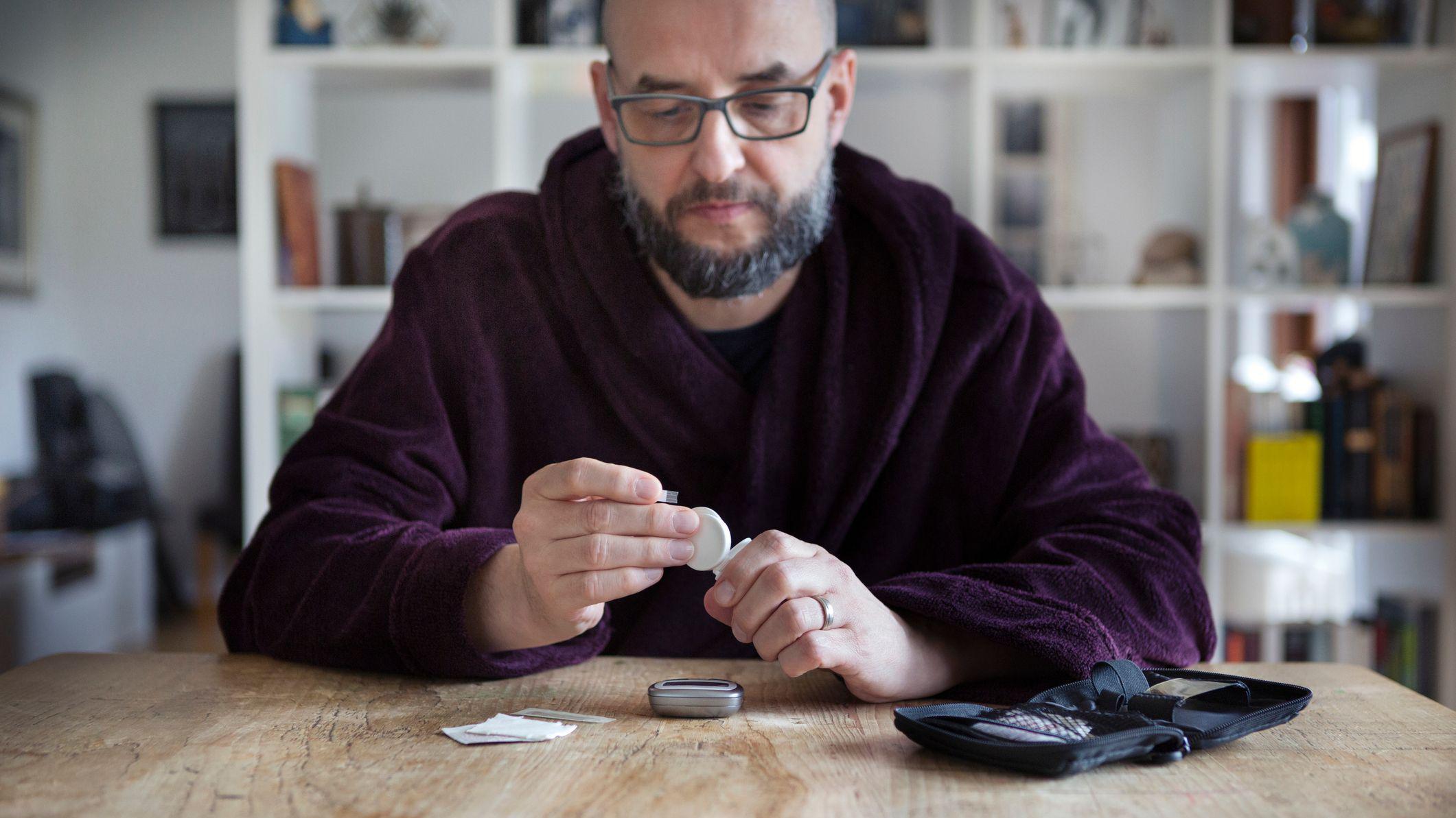 Un hombre mira un frasco de medicamentos