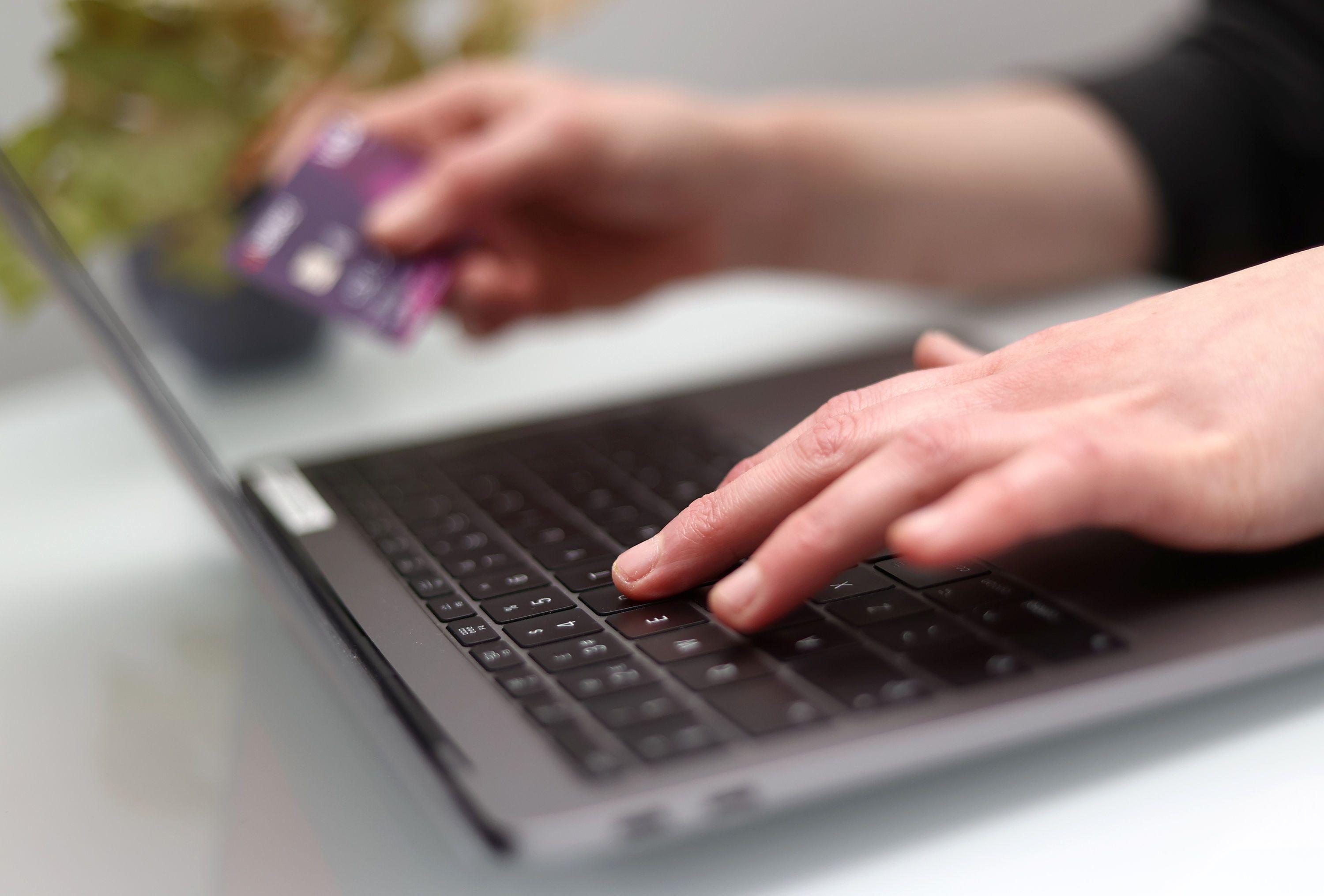 Una persona con una tarjeta bancaria y una laptop