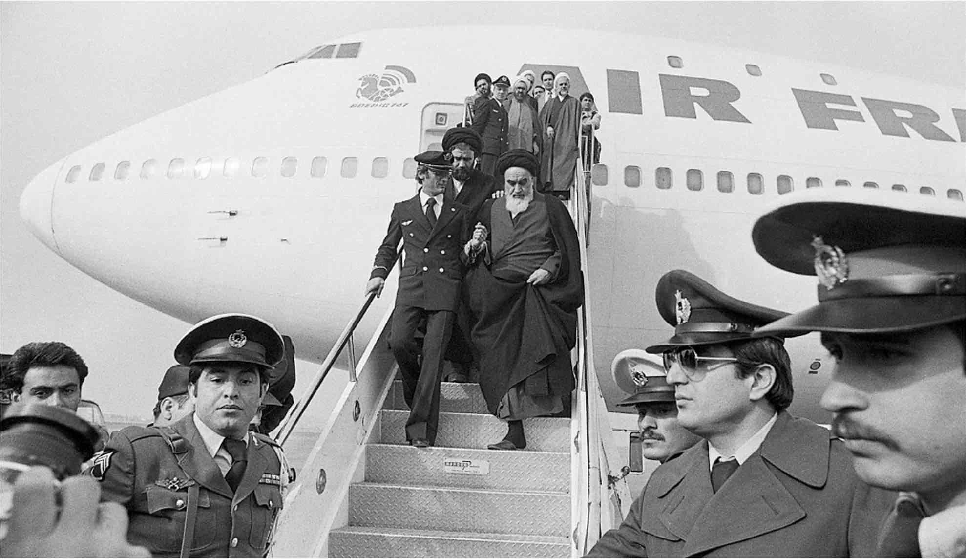 El ayatolá Ruhollah Jomeini sale del avión a su regreso a Irán.