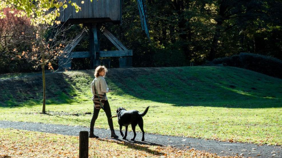 Adriana P caminando con un perro por un parque en Hannover, Alemania