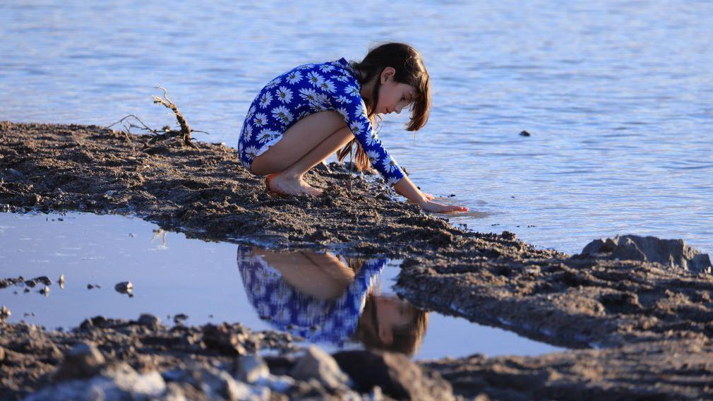 Una niña juega con el agua.