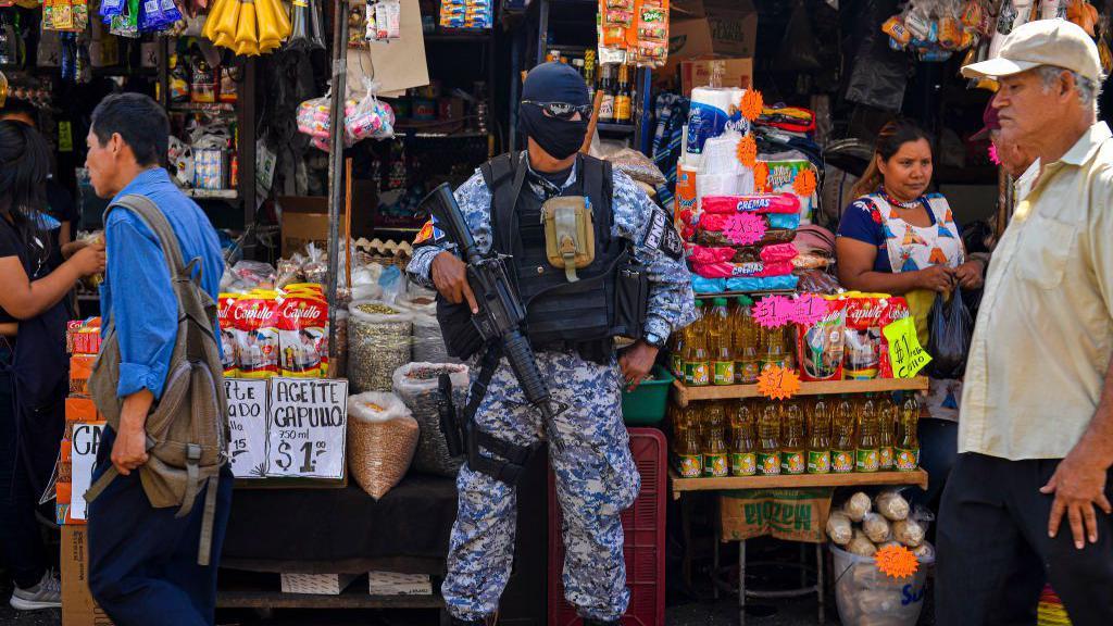 Un miembro del escuadrón táctico de la Policía Nacional se encuentra en un mercado callejero como parte del 'Control Territorial', un plan de seguridad desarrollado por el Gobierno salvadoreño el 18 de enero de 2020 en San Salvador, El Salvador.