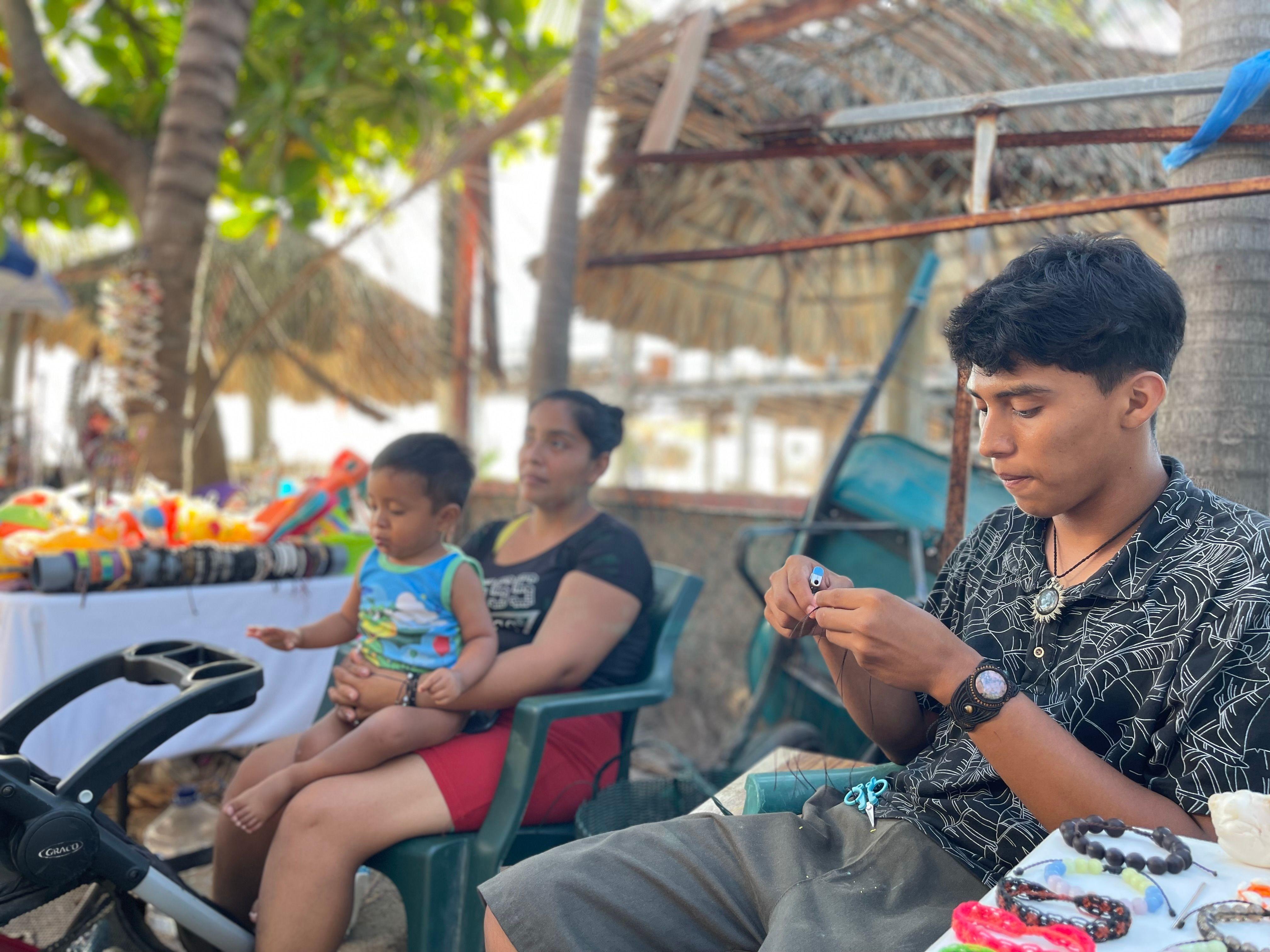 Vanessa y Óscar, dos de los vendedores ambulantes de El Tunco, Surf City, El Salvador, en sus puestos en febrero de 2024.