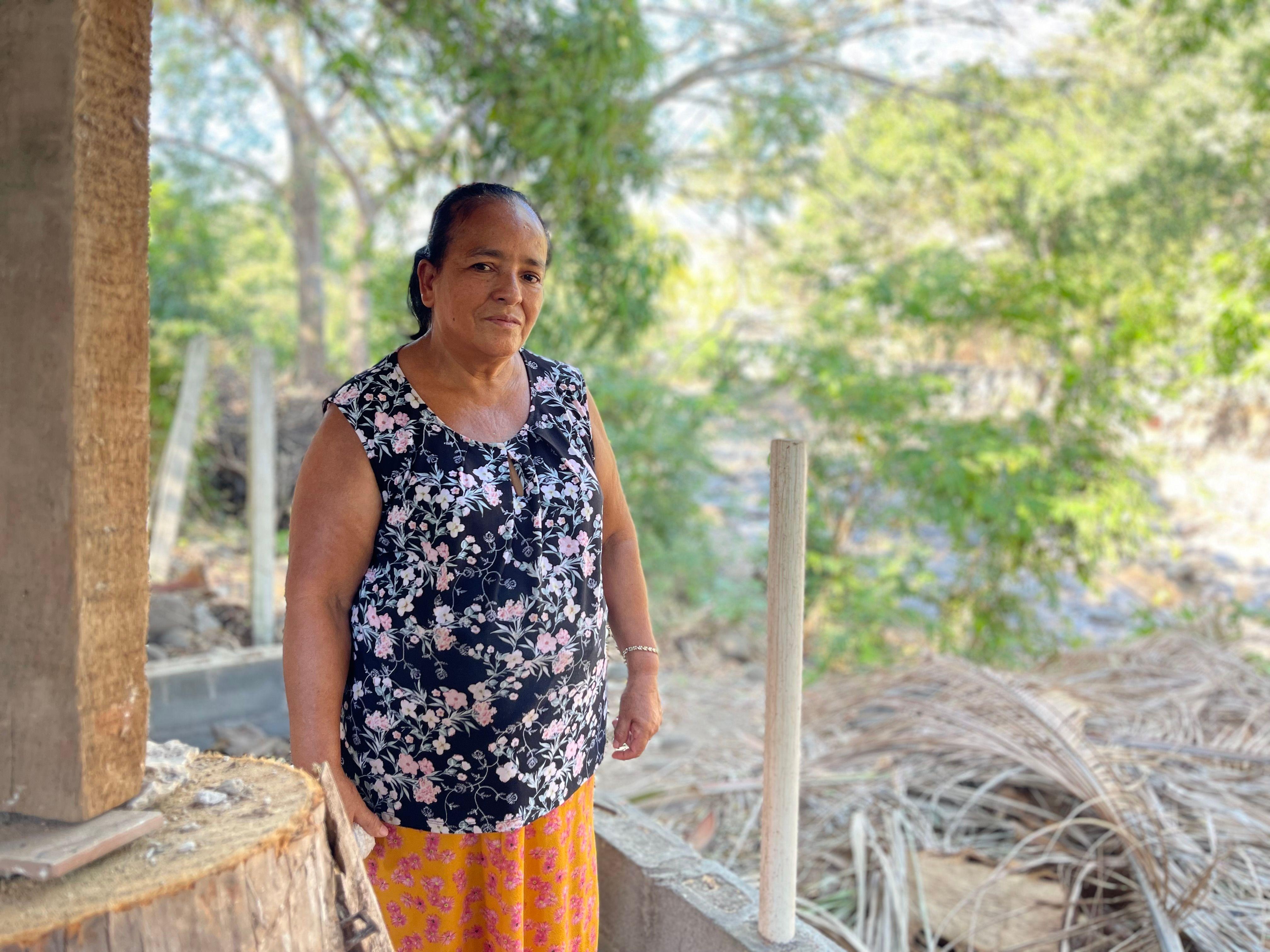 Paula del Carmen Álvarez sentada en su negocio en Chiltiupán, El Salvador, en febrero de 2024.