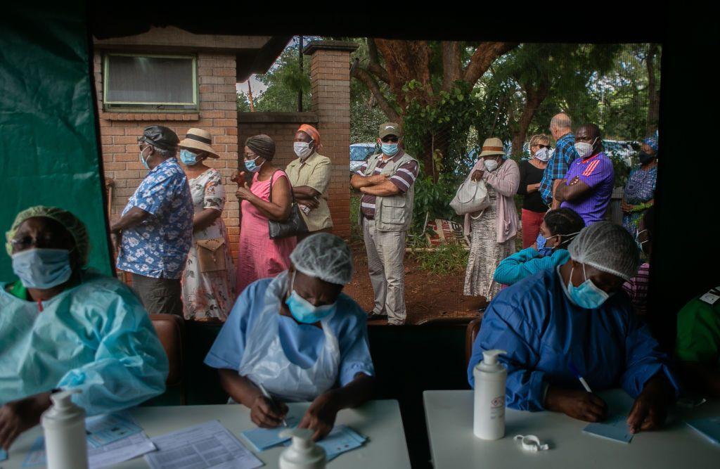 Ancianos hacen cola para recibir la vacuna Sinopharm fuera de la tienda mientras las enfermeras realizan sus tareas en un hospital local el 29 de marzo de 2021 en Harare, Zimbabue.