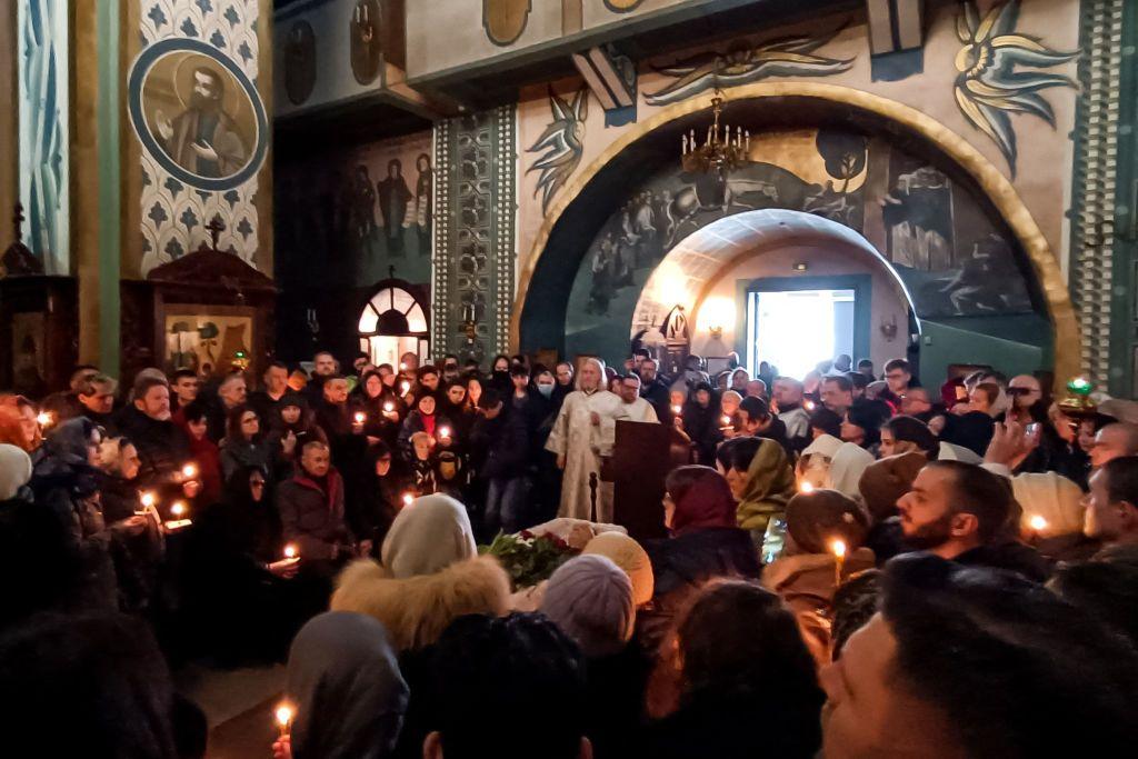 Asistentes al funeral de Navalny dentro de la iglesia sostienen velas.