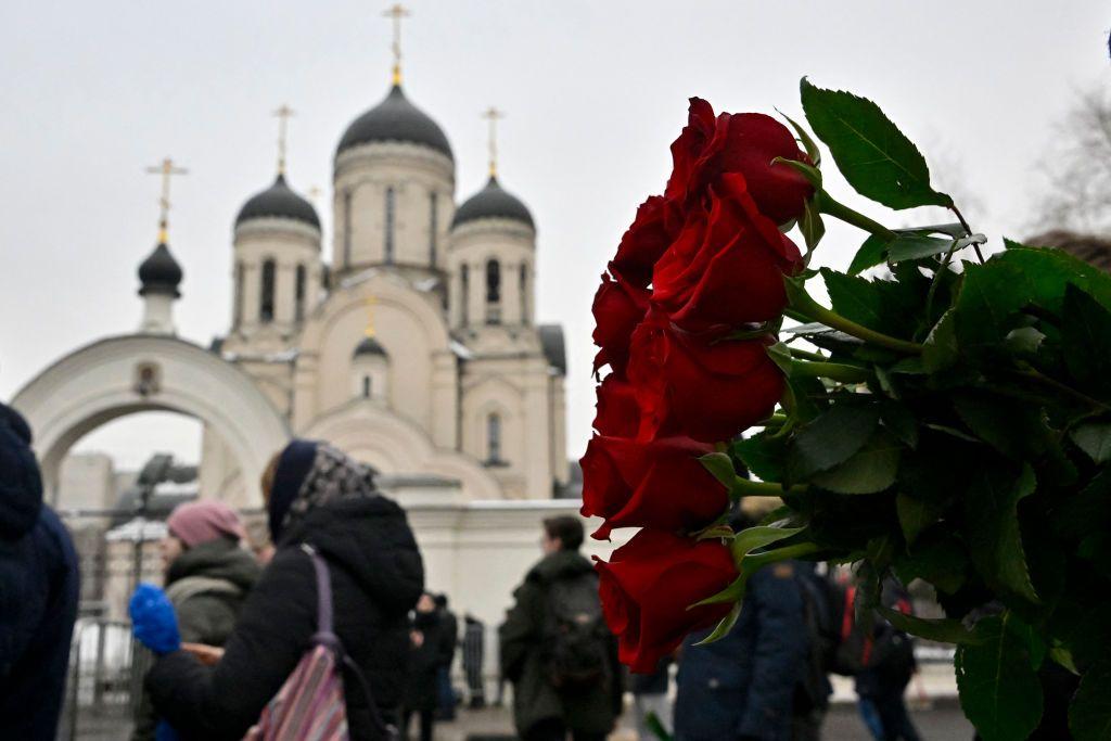 Un ramo de rosas rojas y al fondo de la iglesia.