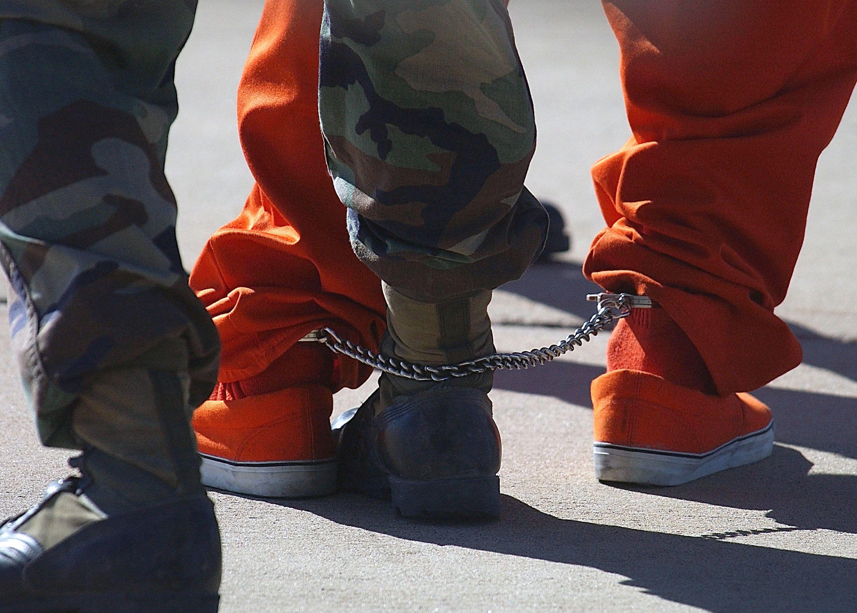 Unos pies de un soldado y de un detenido.