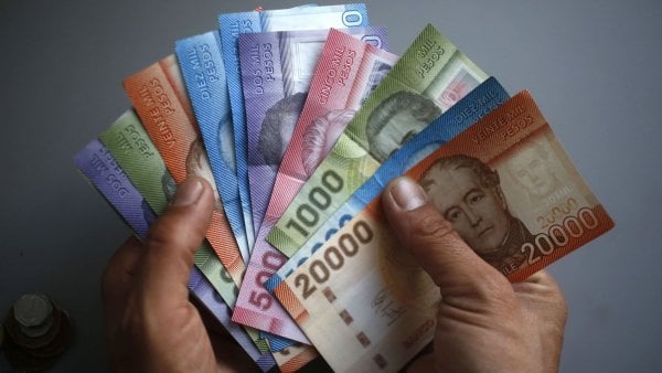 Ex Bono Marzo 2024. Aporte Familiar Permanente. Mano con billetes.